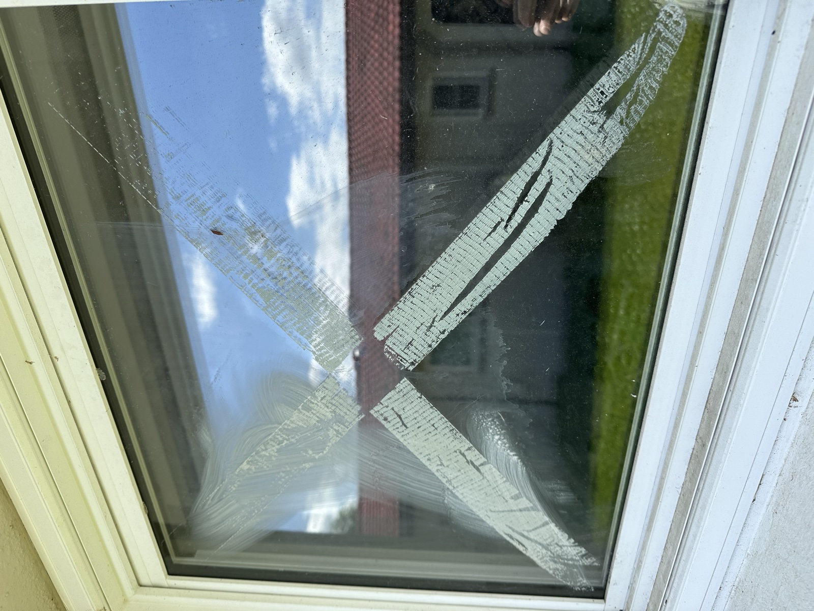 Window with tape residue and hard-water stains before cleaning