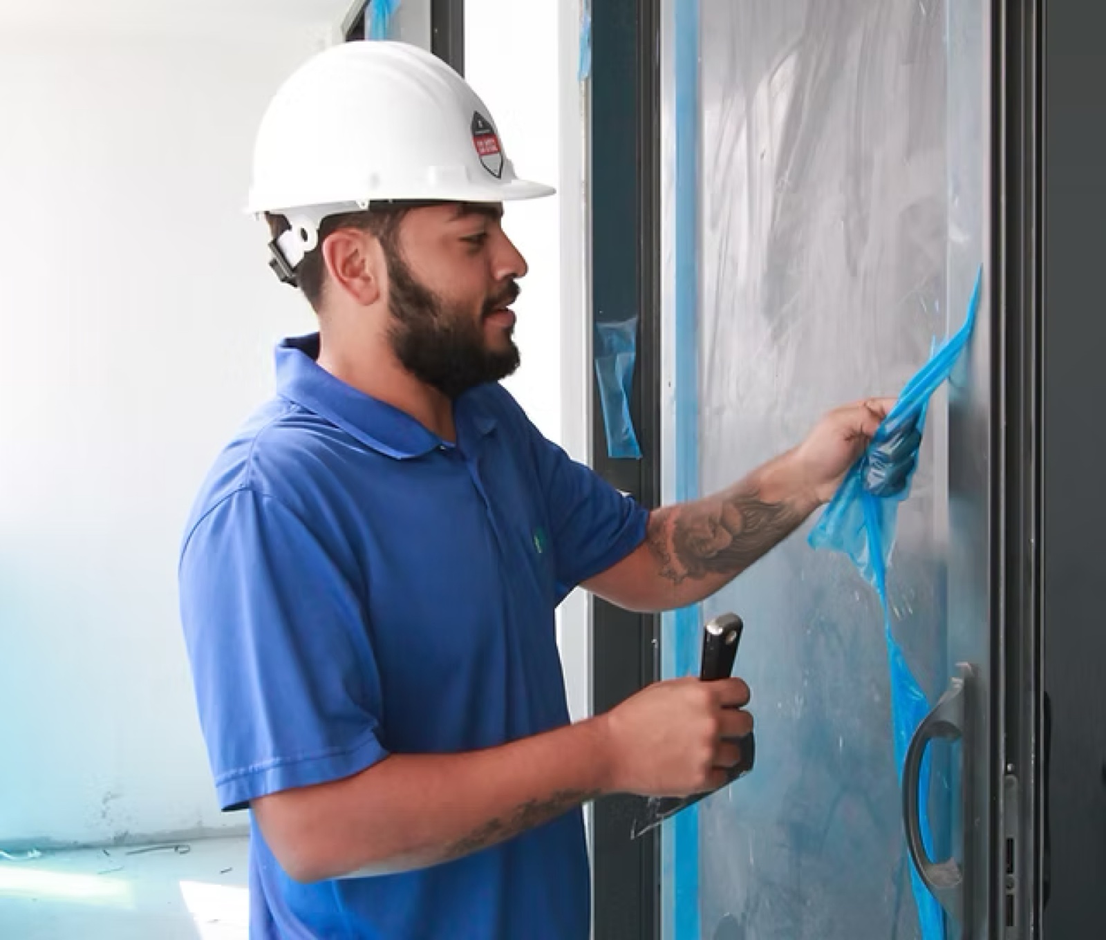 Drift technician removing protective film from new-build glass door